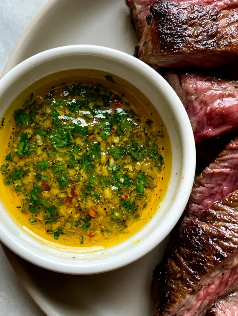 Cowboy Butter Sauce: The Ultimate 5-Minute Dipping Sauce for Steak 1 Slices of medium-rare steak with a dark crust next to a bowl of garlicky Cowboy Butter Sauce.