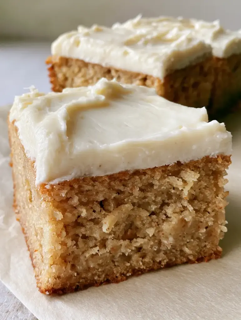Overhead view of rectangular banana bread brownies with a thick layer of smooth cream cheese frosting.