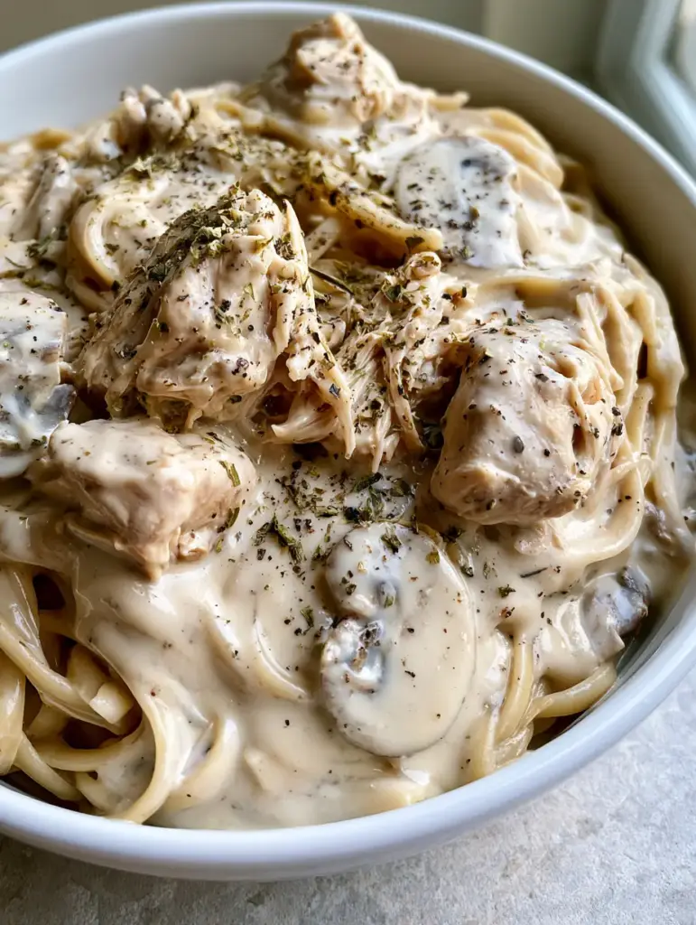 A glistening bed of al dente linguine pasta intertwined with thick cream cheese and mushroom sauce. (Crockpot Angel Chicken)